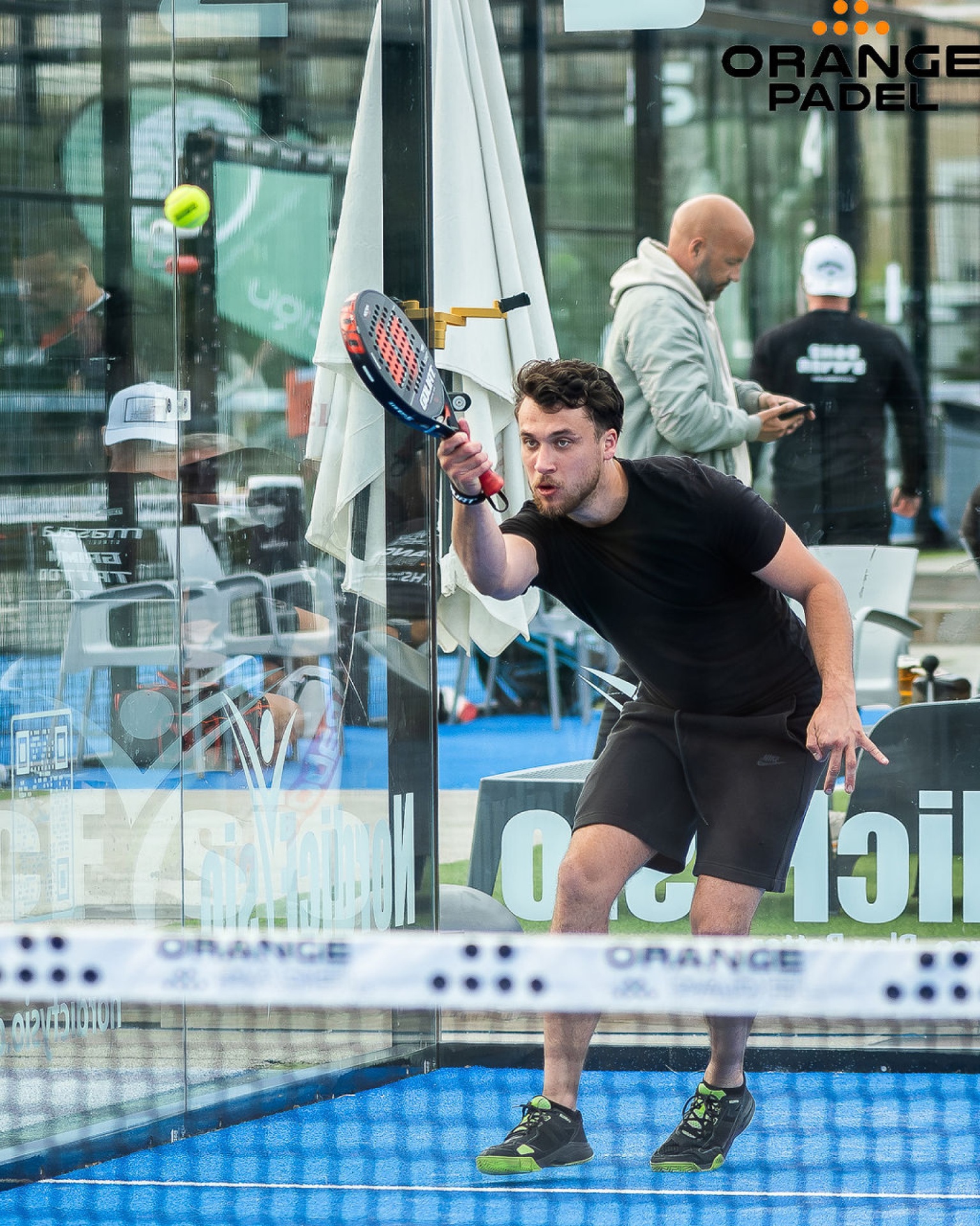 Spelare slår en stretch-volley vid nätet