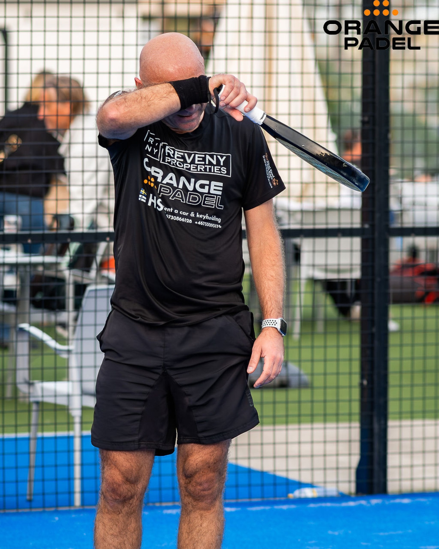 Spelare i Reveny Properties Orange Padel-tröja torkar pannan